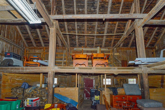 miscellaneous room with wooden walls and lofted ceiling