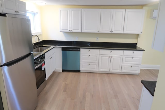 kitchen featuring white cabinets, appliances with stainless steel finishes, light hardwood / wood-style floors, and sink