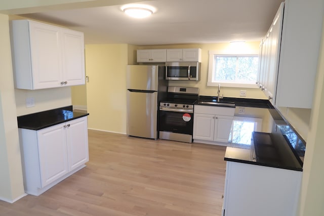 kitchen with white cabinetry, sink, light wood-type flooring, and appliances with stainless steel finishes