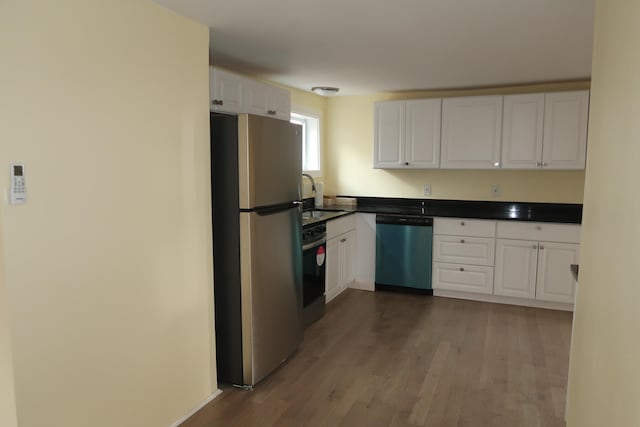 kitchen featuring appliances with stainless steel finishes, sink, white cabinetry, and wood-type flooring