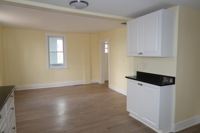 kitchen with light wood-type flooring and white cabinetry