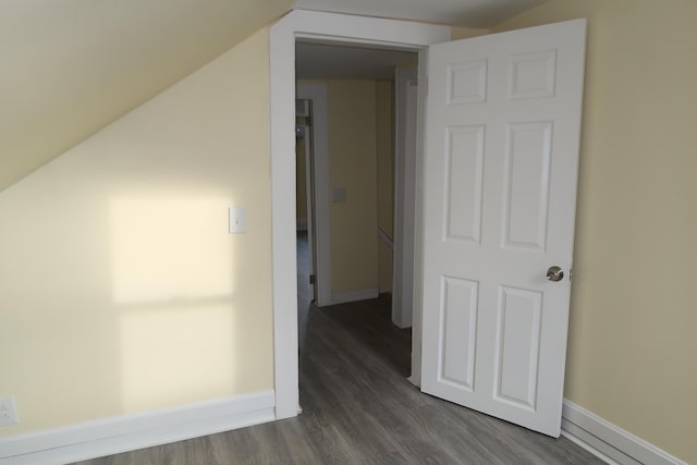 hall with dark hardwood / wood-style flooring and lofted ceiling