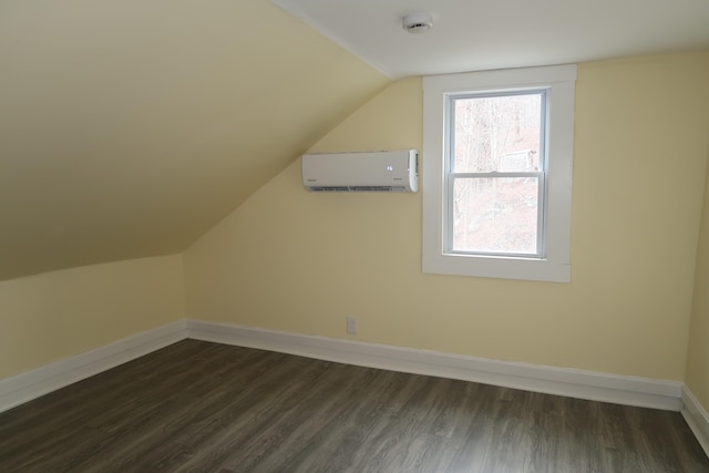 bonus room with dark hardwood / wood-style flooring, an AC wall unit, and vaulted ceiling