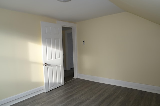 unfurnished room with dark hardwood / wood-style floors and vaulted ceiling