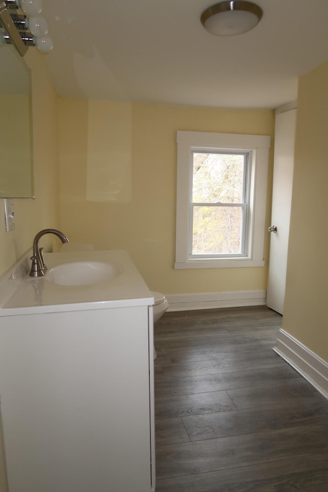 bathroom with hardwood / wood-style floors, vanity, and toilet