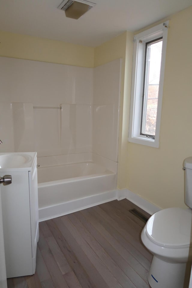 full bathroom with shower / bath combination, vanity, wood-type flooring, and toilet