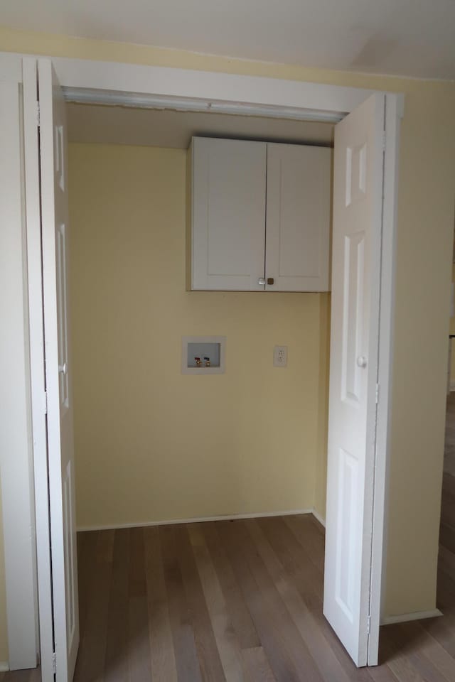 laundry area with cabinets, hookup for a washing machine, and light hardwood / wood-style floors