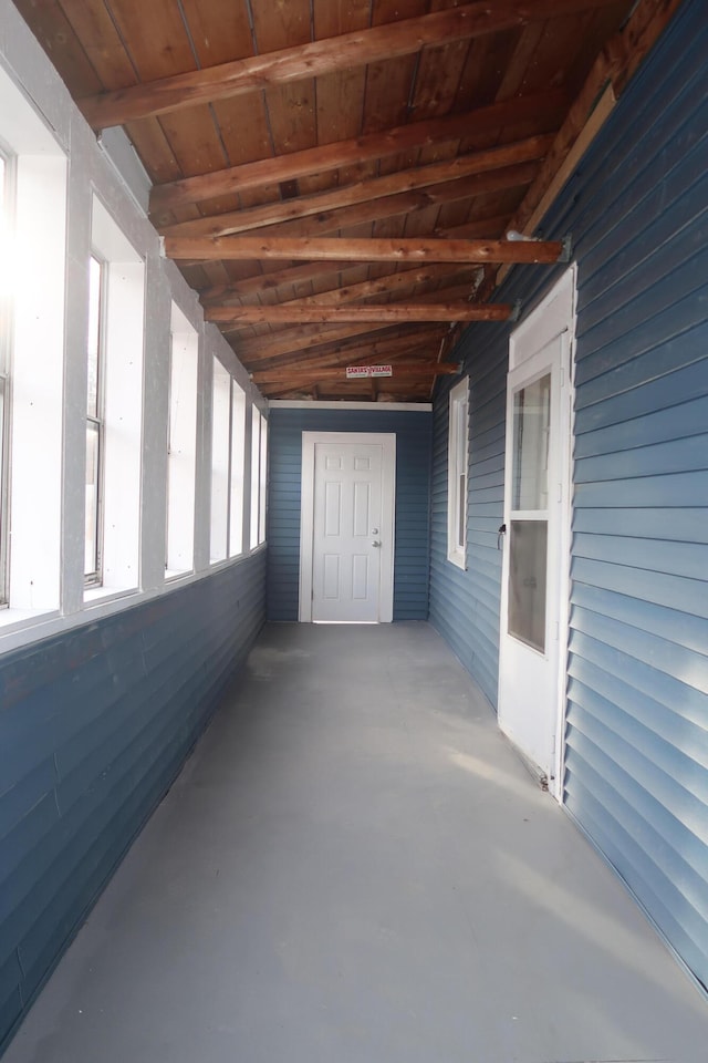 unfurnished sunroom featuring wood ceiling and vaulted ceiling