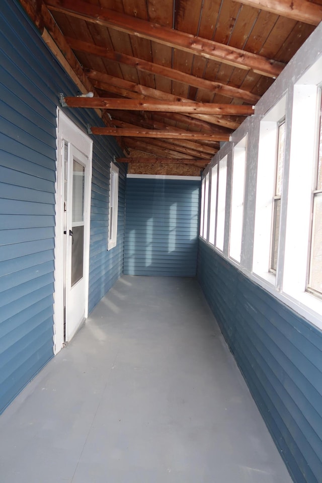 unfurnished sunroom with beam ceiling and wood ceiling