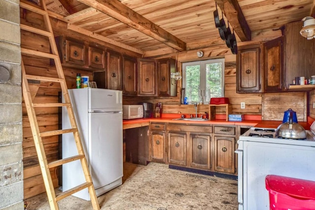 kitchen featuring beam ceiling, sink, wooden ceiling, and white appliances