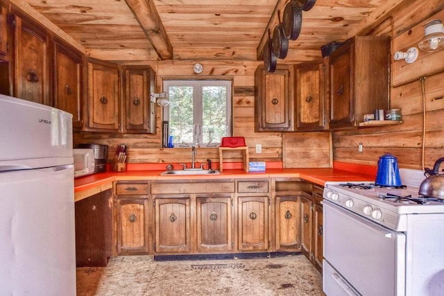 kitchen featuring white appliances, wood ceiling, wood walls, and sink