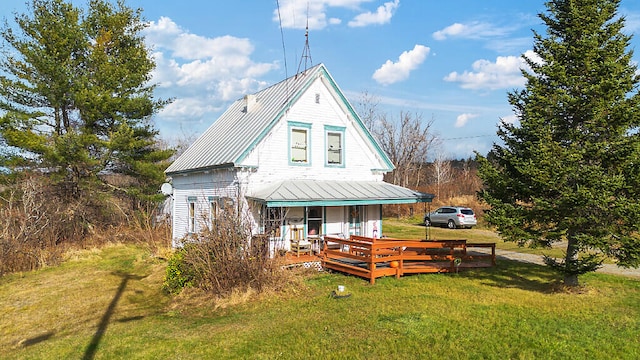 back of property featuring covered porch and a yard