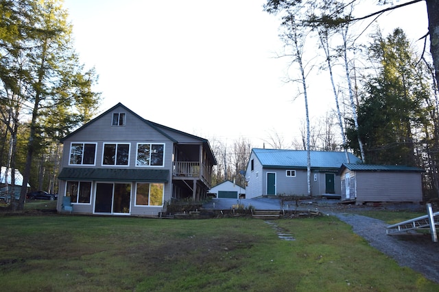 rear view of house featuring an outbuilding and a yard