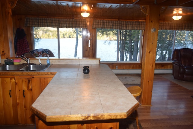 kitchen featuring hardwood / wood-style flooring, wooden ceiling, sink, and tile countertops