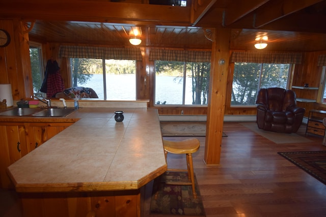 kitchen featuring tile counters, sink, wooden ceiling, and hardwood / wood-style flooring