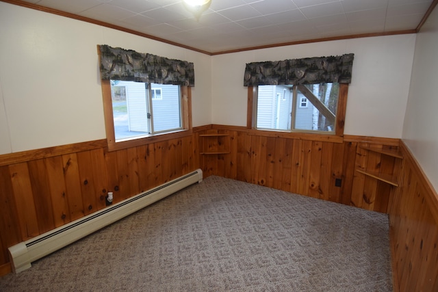 spare room with ornamental molding, wooden walls, and a baseboard heating unit