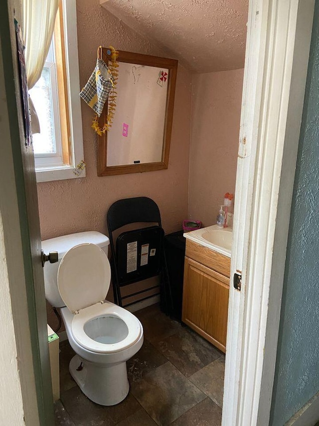 bathroom featuring vanity, toilet, and a textured ceiling