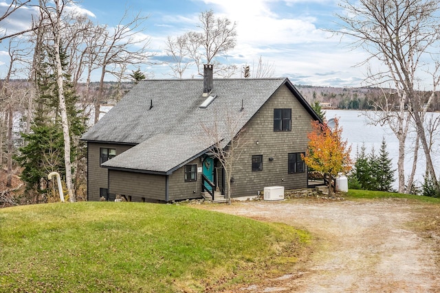 rear view of house featuring a yard and a water view