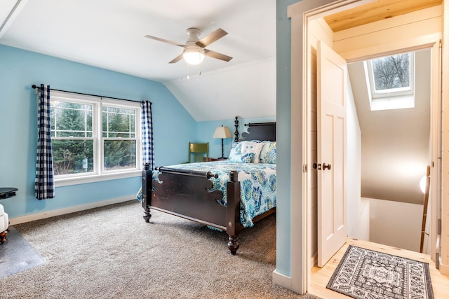 bedroom with ceiling fan, light colored carpet, and lofted ceiling with skylight