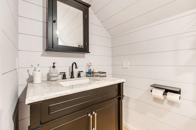 bathroom with vanity and lofted ceiling