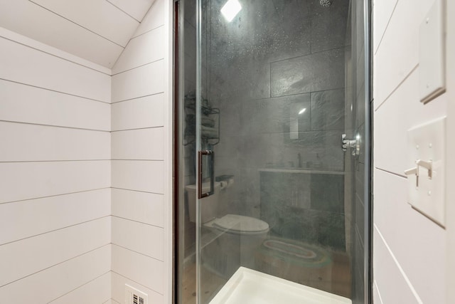 bathroom featuring an enclosed shower, vaulted ceiling, and toilet