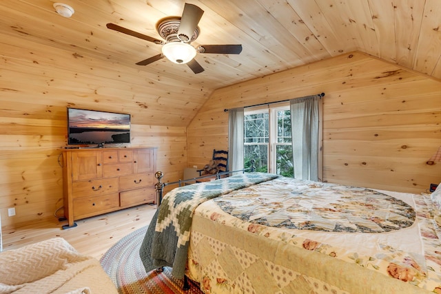 bedroom featuring light hardwood / wood-style flooring, vaulted ceiling, and wood walls