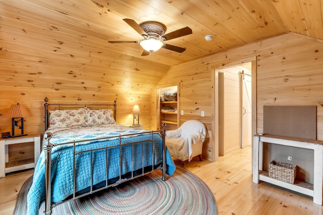 bedroom with ceiling fan, light hardwood / wood-style flooring, lofted ceiling, wooden walls, and wood ceiling