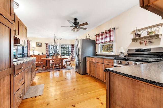 kitchen featuring light hardwood / wood-style floors, a healthy amount of sunlight, ceiling fan with notable chandelier, and appliances with stainless steel finishes