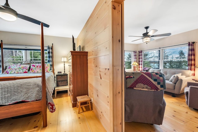 bedroom featuring multiple windows, ceiling fan, and light hardwood / wood-style floors