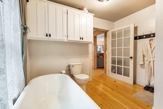 bathroom featuring a bathtub, wood-type flooring, and toilet