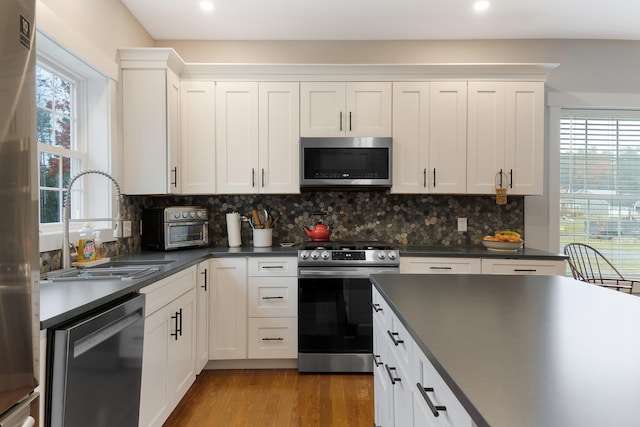 11 Beacon Dr, Brunswick, ME 04011 - kitchen with tasteful backsplash, stainless steel appliances, sink, white cabinets, and light hardwood / wood-style floors
