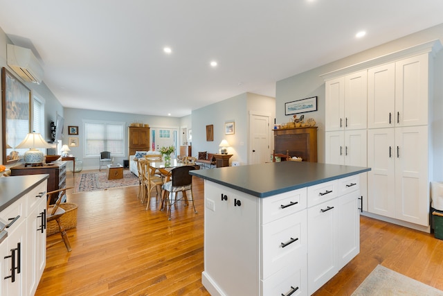 11 Beacon Dr, Brunswick, ME 04011 - kitchen featuring a center island, light hardwood / wood-style flooring, white cabinets, and a wall mounted air conditioner