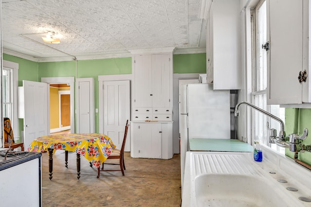 kitchen with sink, white cabinets, a healthy amount of sunlight, and white refrigerator