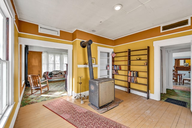 interior space with a wood stove and light hardwood / wood-style flooring