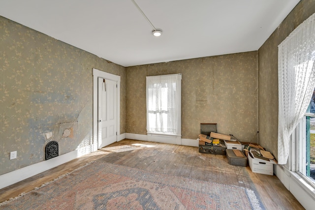 236 High St, Farmington, ME 04938 - empty room featuring wood-type flooring, plenty of natural light, and wallpapered walls