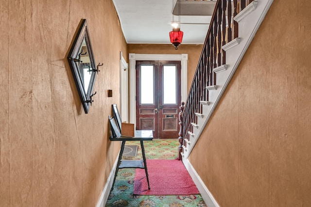 entrance foyer featuring wood walls and french doors