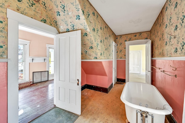 236 High St, Farmington, ME 04938 - bathroom featuring wallpapered walls, a soaking tub, and a wainscoted wall