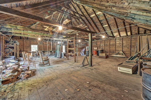 misc room featuring hardwood / wood-style flooring, vaulted ceiling with beams, and wooden walls