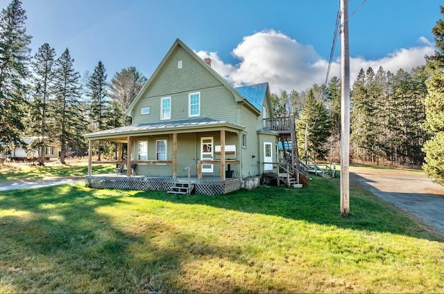 rear view of property with a porch and a yard