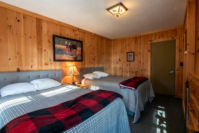 carpeted bedroom featuring wooden walls