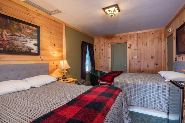 bedroom with wood walls, crown molding, and carpet floors