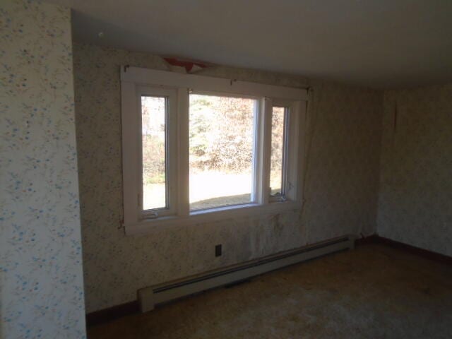 unfurnished room with a baseboard heating unit