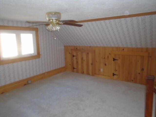 bonus room featuring carpet flooring, a textured ceiling, ceiling fan, and lofted ceiling