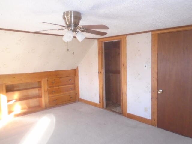 bonus room featuring a textured ceiling, light colored carpet, and ceiling fan