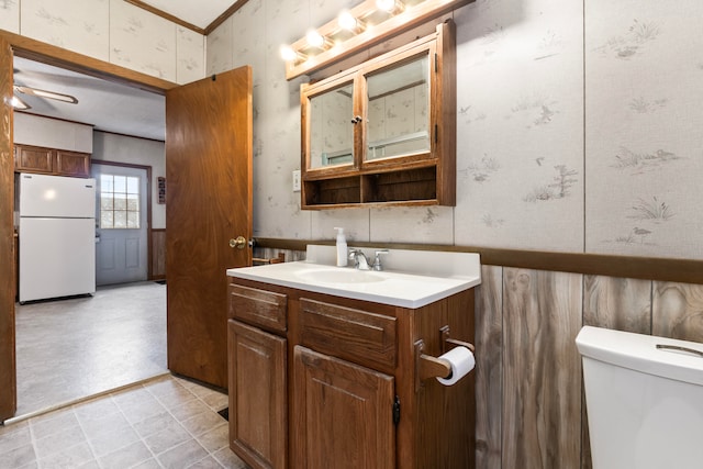 bathroom with vanity, toilet, and crown molding