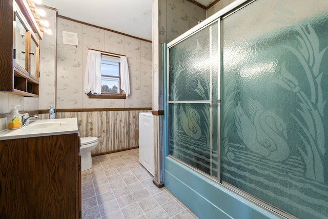 full bathroom with vanity, toilet, ornamental molding, and bath / shower combo with glass door