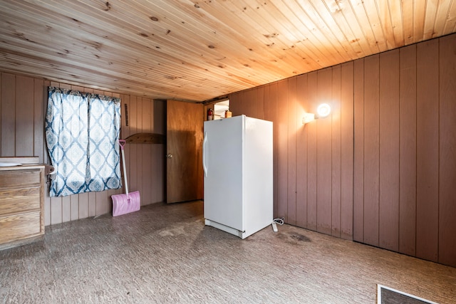 spare room with wooden walls, wooden ceiling, and light carpet