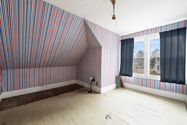 additional living space featuring lofted ceiling and light hardwood / wood-style flooring