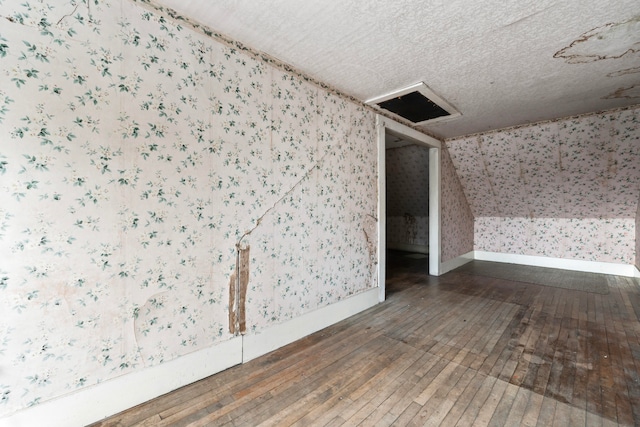 bonus room with dark hardwood / wood-style floors and vaulted ceiling