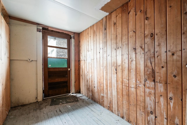 entryway with wooden walls and light hardwood / wood-style flooring